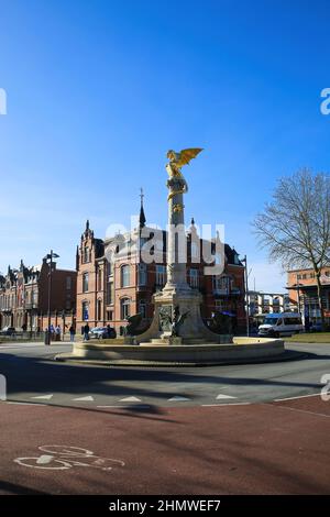 S Hertogenbosch, Niederlande - Februar 9. 2022: Blick auf den Kreisverkehr mit Drakenfontain-Skulptur mit alten historischen Häusern gegen den blauen Winter Stockfoto