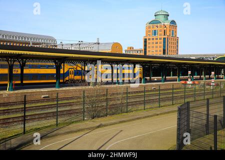 S Hertogenbosch, Niederlande - Februar 9. 2022: Blick auf die Rückseite des Hauptbahnhofs mit Schienen und modernen Architekturgebäuden Stockfoto