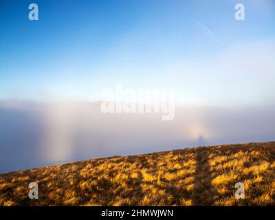 Die Helvellyn Bergkette mit Striding Edge, die aus dem Tal Nebel von einer Temperaturinversion im Lake District bei der Morgendämmerung stochen, aus der Summe Stockfoto