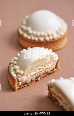 Knusprige Tarte mit zarter weißer Schokoladenmousse und gesalzenem Karamell. Platz für Text kopieren. Morgens Kuchen zum Frühstück. Stockfoto