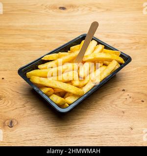 Belgische Pommes in schwarzer Schale Stockfoto