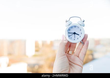 Hand mit Armmuhr, die 15,45 Uhr während der Hauptverkehrszeit in der Stadt zeigt.Rush Hour in der Großstadt.Konzept der Deadline, Zeitoptimierung.Raum kopieren Stockfoto