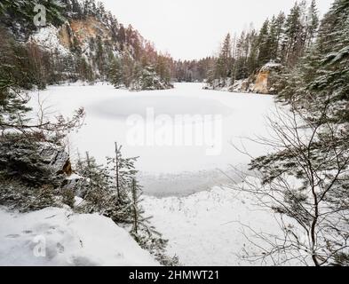 Gefrorener blauer See im Naturpark Adrspach. Winterwandern in beliebt in felsigen Labyrinth in der Tschechischen Republik Stockfoto