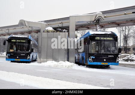 Moskau, Russland - 30. Januar 2022: Elektrobus an der Ladestation während des Ladevorgangs. Arbeiten Sie unter harten Winterbedingungen. Stockfoto