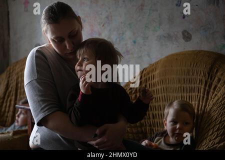 Gornyak, Ukraine. 09th. Februar 2022. Eugenia Mazur, 26, Holds Andrey, Alter 2, am 9. Februar, 2022. Igor und Eugenia Mazur, die Eltern von 5 Kindern, die alle unter 8 Jahre alt sind, leben etwa 10 Meilen von der Donezker Front in Gornyak, Ukraine. Die Familie kämpft darum, genügend Arbeit für Lebensmittel und Rechnungen zu finden und bleibt besorgt, während die russischen Streitkräfte an der ukrainischen Grenze mobilisieren. (Foto von Michael Nigro/Sipa USA) Quelle: SIPA USA/Alamy Live News Stockfoto