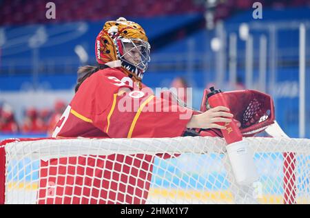 (220212) -- PEKING, 12. Februar 2022 (Xinhua) -- Torhüterin Zhou Jiaying aus China bekommt ihre Wasserflasche für einen Drink im Wukesong Sportzentrum in Peking, der Hauptstadt von China, am 7. Februar 2022. Hinter dem Tor gibt es einen besonderen Platz, um eine Wasserflasche für den Torwart aufzuhängen. Als die chinesischen Eishockeyspieler bei den Olympischen Winterspielen 2022 in Peking auftauchten, zieht dieses Spiel immer mehr die Aufmerksamkeit der Öffentlichkeit auf sich. Im Wukesong Sports Center in Peking stellten Mitarbeiter der Eishockey-Veranstaltungen die Eiswürfel in Kühlboxen. Der Puck aus vulkanisiertem Gummi ist eine flache harte Scheibe, die benötigt wird Stockfoto