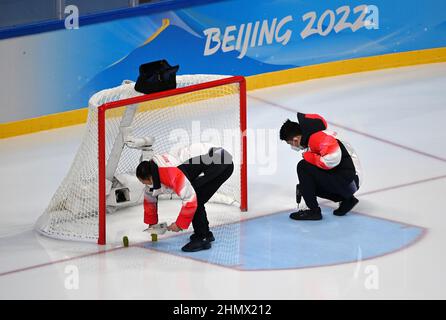 (220212) -- PEKING, 12. Februar 2022 (Xinhua) -- Mitarbeiter installieren ein Eishockey-Tor mit Elektrobohrern im Wukesong Sports Center in Peking, der Hauptstadt von China, 8. Februar 2022. Als die chinesischen Eishockeyspieler bei den Olympischen Winterspielen 2022 in Peking auftauchten, zieht dieses Spiel immer mehr die Aufmerksamkeit der Öffentlichkeit auf sich. Im Wukesong Sports Center in Peking stellten Mitarbeiter der Eishockey-Veranstaltungen die Eiswürfel in Kühlboxen. Der Puck aus vulkanisiertem Gummi ist eine flache Festplatte, die vor dem Spiel eingefroren werden muss, um die Elastizität während des Spiels zu verringern. Die Männer und Frauen Stockfoto