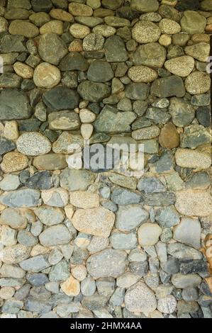 Das Foto von unterschiedlich großen und unterschiedlich farbigen Steinen ist sowohl für ein Muster als auch für die Textur von Baustoffen oder Landschaftsgestaltung perfekt. Stockfoto