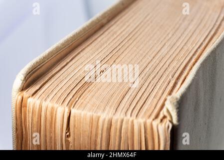 Altes Buch mit vergilbten Seiten und einem Stoffeinband. Dickes Buch isoliert auf weißem Hintergrund. Stockfoto