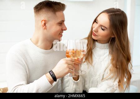 Junge schöne Menschen trinken Wein aus Gläsern, um Bekanntschaft zu feiern. Liebe auf den ersten Blick. Romantische Beziehungen. Liebe und Zärtlichkeit Stockfoto