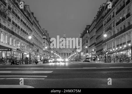 Paris, Frankreich - 11. Februar 2022 : geschäftiges Treiben auf einem Boulevard in Paris und das berühmte Pantheon-Denkmal im Hintergrund bei Nacht Stockfoto