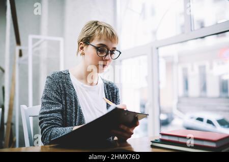 Executive Frau mit Zwischenablage arbeitet im Büro Stockfoto