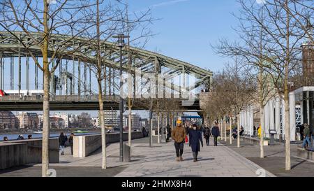 Menschen, die an einem strahlenden Wintertag auf dem Rheinboulevard in Köln spazieren gehen Stockfoto