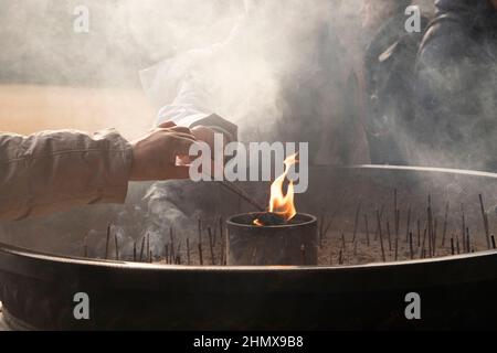 Weihrauch Licht japanischen Tempel im Winter mit Rauch und Menschen beten, Flammen brennen in Sand Weihrauchtopf. Asiatische Kultur, asiatische Religionen, Japaner Stockfoto