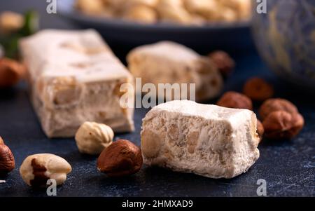 Weiche Nougats mit Haselnüssen auf rustikalem Tisch. Stockfoto