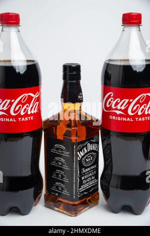 Riga, Lettland Februar 12,2022:Foto von Coca-Cola Plastikflasche und Jack Daniel Whiskey isoliert auf weißem Hintergrund mit Schneideweg Stockfoto