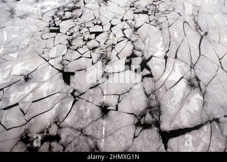 Zerbrochene Eisschollen, die auf der Flußluftaufnahme von der Drohne aus schweben Stockfoto