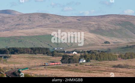 GB Railfreight Lok der Baureihe 66 66709 auf der Hauptlinie der Westküste im ländlichen Cumbria, vorbei an Scout Green mit einem Zug von Armeeläden Stockfoto