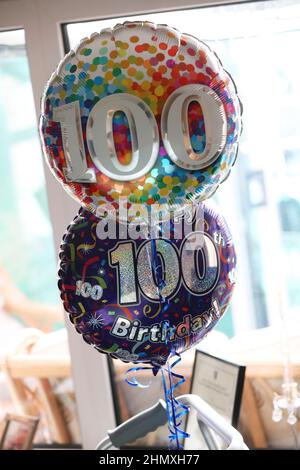 Ballons zum 100. Geburtstag auf einer Geburtstagsparty in Chichester, West Sussex, Großbritannien. Stockfoto