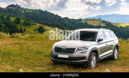 Mizhirya, Ukarine - AUG 08, 2020: suv auf einer Hangwiese. Schöne Sommerlandschaft an einem sonnigen Tag. Reise Land und Sommerurlaub Konzept Stockfoto