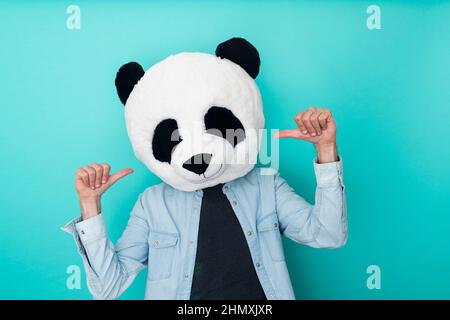 Fröhliche Person in Panda-Maske zeigt sich im Studio Stockfoto