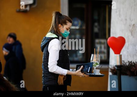 Am 12. Februar 2022 wird in der Altstadt von Warschau, Polen, ein Kellner mit Gesichtsmaske gesehen. Gesundheitsminister Adam Niedzielski gab diese Woche bekannt, dass Stockfoto