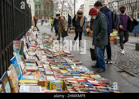 Bukarest, Rumänien - 02. Februar 2022: In der Innenstadt von Bukarest, Rumänien, kaufen Menschen Bücher von einer Street Antique. Stockfoto