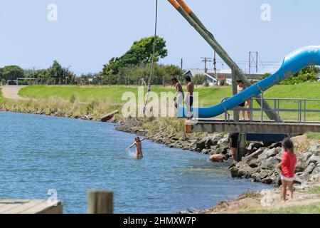 Opotiki Neuseeland - Januar 30 2022; Junge Leute springen in den Otara River und genießen sommerlichen Spaß Stockfoto