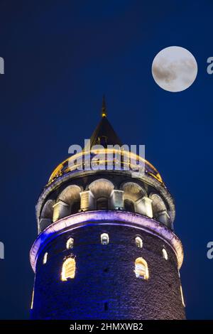 Vertikale Aufnahme des Galata-Turms in Istanbul, Türkei, bei Nacht mit Vollmond Stockfoto