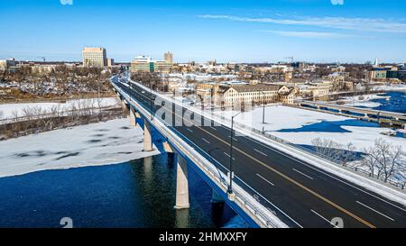 Verkehr über die Brücke, die in die Stadt führt - appleton, wisconsin usa. Alte Gebäude an der Seite, die Geschichte zeigen. Stockfoto