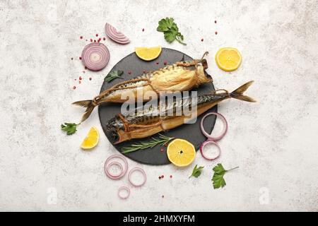 Tafel mit leckeren geräucherten Makrelenfischen auf hellem Hintergrund Stockfoto