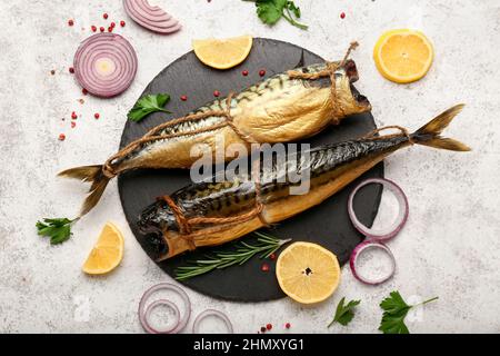 Tafel mit leckeren geräucherten Makrelenfischen auf hellem Hintergrund Stockfoto