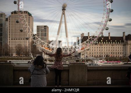 London, Großbritannien. 12th. Februar 2022. Touristen sahen Fotos mit dem London Eye im Hintergrund machen.als die Gespräche über einen vollständigen Auftrieb der Coronavirus-Beschränkungen auftauchen, steigt der Tourismus in der Hauptstadt und das Stadtleben normalisiert sich weiter. Kredit: SOPA Images Limited/Alamy Live Nachrichten Stockfoto