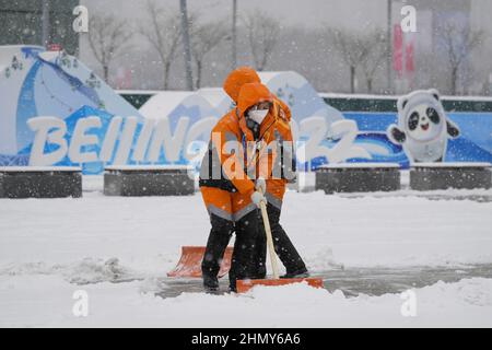 Peking, China. 12th. Februar 2022. Arbeiter schaufeln Neuschnee, der sich über Nacht vor dem Hauptmedienzentrum bei den Olympischen Winterspielen 2022 in Peking am Sonntag, dem 13. Februar 2022 angesammelt hat. Foto von Paul Hanna/UPI Credit: UPI/Alamy Live News Stockfoto