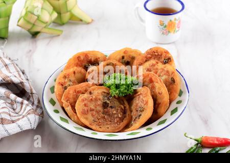 OTE-ote oder Bala-Bala ist Gemüsefritter auf einem Enemel-Teller mit grünem Chili für Gorengan Takjil Ramadan. Stockfoto