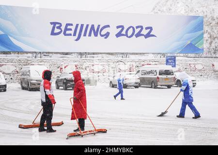 Zhangjiakou, Chinas Provinz Hebei. 13th. Februar 2022. Mitarbeiter reinigen Schnee vor dem Zhangjiakou Mountain Press Center in Zhangjiakou, nordchinesische Provinz Hebei, 13. Februar 2022. Quelle: Peng Ziyang/Xinhua/Alamy Live News Stockfoto