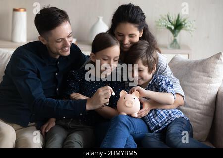 Glückliche Familie spart Geld für zukünftige Einkäufe Stockfoto