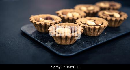 Nahaufnahme von Cookies in Form von Körben mit Nussfüllung. Stockfoto