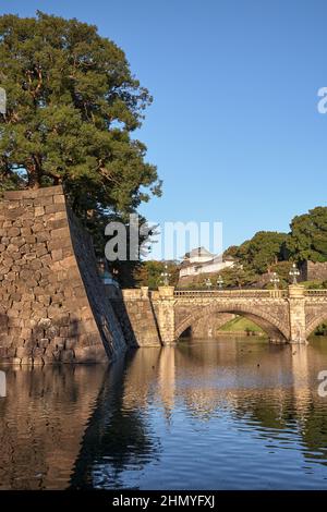 Der Blick auf die SeidenIshibashi-Brücke (ein Spitzname ist Meganebashi oder Brillen) über das Wasser des Nijubashi-Grabens und des Fushimi-Turms von Kyuden aus gesehen Stockfoto