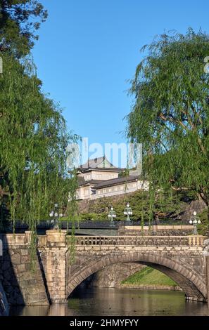 Der Blick auf die SeidenIshibashi-Brücke (ein Spitzname ist Meganebashi oder Brillen) über das Wasser des Nijubashi-Grabens und des Fushimi-Turms von Kyuden aus gesehen Stockfoto