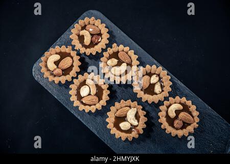 Nahaufnahme von Cookies in Form von Körben mit Nussfüllung. Stockfoto