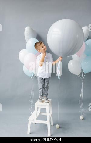 Geschlecht zeigen Partei. Ein vierjähriges Kind hält einen Ballon in den Händen, um das Geschlecht des ungeborenen Kindes in der Familie herauszufinden. Geburtstag des Kindes Stockfoto