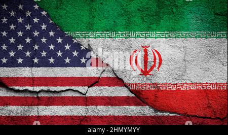 Vollformatfoto von verwitterten Flaggen der Vereinigten Staaten (USA, USA, Amerika) und des Iran, gemalt auf einer rissigen Wand. KONFLIKTKONZEPT ZWISCHEN DEN USA und dem Iran. Stockfoto