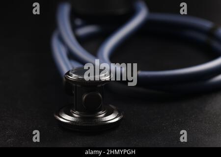 Medizinisches Stethoskop-Instrument auf schwarzer Oberfläche, Werkzeug für die Patientendiagnostik Stockfoto