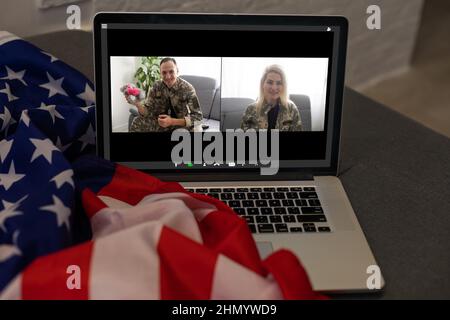 Reifer männlicher Soldat, der im Hauptquartier einen Laptop für die Kommunikation mit seiner Familie verwendet. Stockfoto