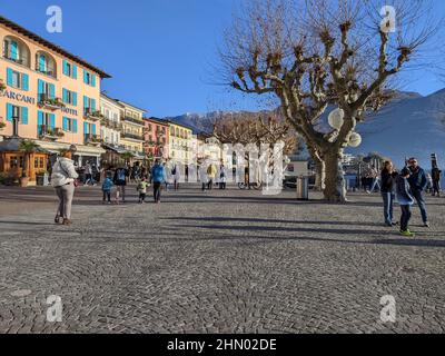 ASCONA, SCHWEIZ - 20. JANUAR 2022: Die Menschen genießen den sonnigen Wintertag an der Promenade entlang des Sees Stockfoto