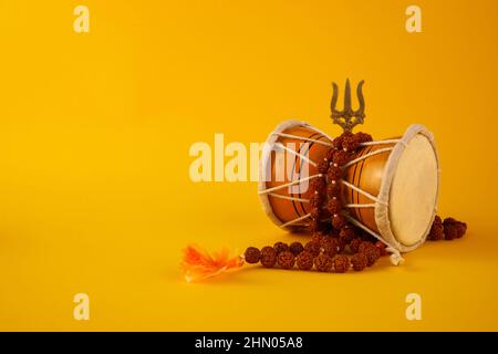 Shivaratri Hintergrund mit Shivas Dreizack und Pellet Drum Damroo Musikinstrument . Hindu-Fest Maha Shivratri Stockfoto