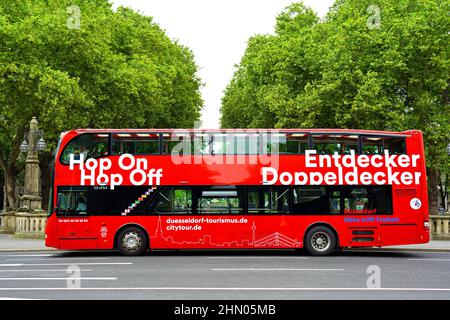 Rote Doppeldecker-Stadtrundfahrt 'Hop on / Hop off'-Bus wartet an einer Haltestelle in der Königsallee in Düsseldorf/Deutschland. Stockfoto