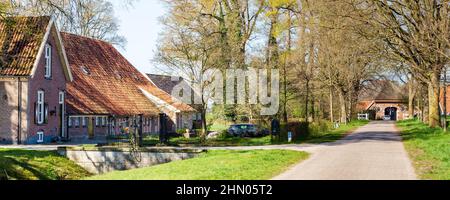Holländische Landschaftlandschaft mit Straßen- und Bauernhäusern in der Nähe von Diepenheim Hof van Twente in Gelderland Stockfoto