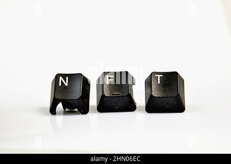 NFT-Text mit verwendeten schwarzen Computertasten auf Weiß. Stockfoto